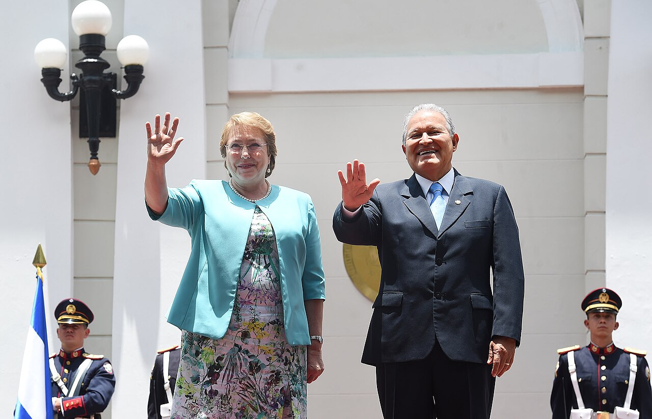 Two presidents wave from the steps of the Presidential House in San Salvador, with uniformed honour guards at either side