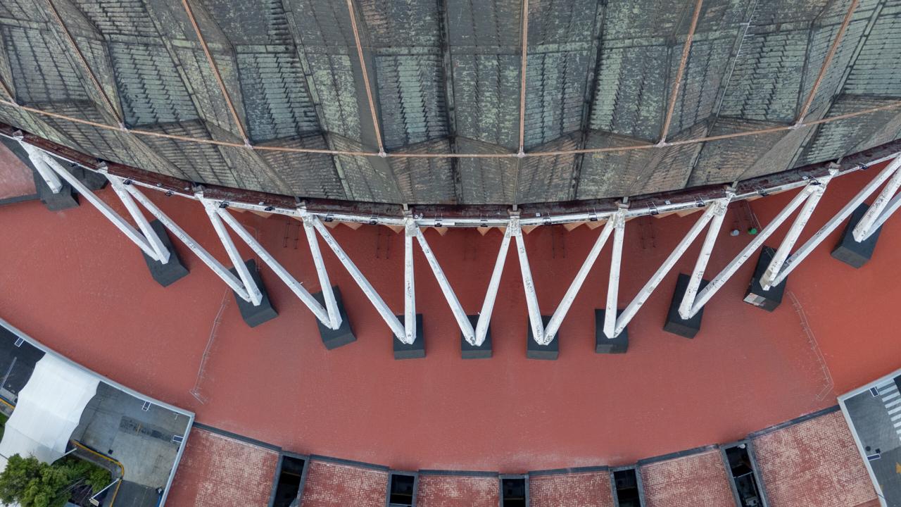 Aerial view of the copper dome and white support struts of the Palacio de los Deportes arena in Mexico City.