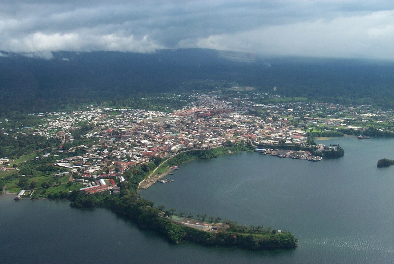 Aerial view of Malabo, the capital of Equatorial Guinea, on the coast of Bioko Island with forested hills behind the city