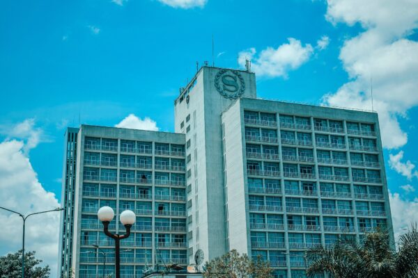 Sheraton Kampala Hotel tower under a blue sky with white clouds