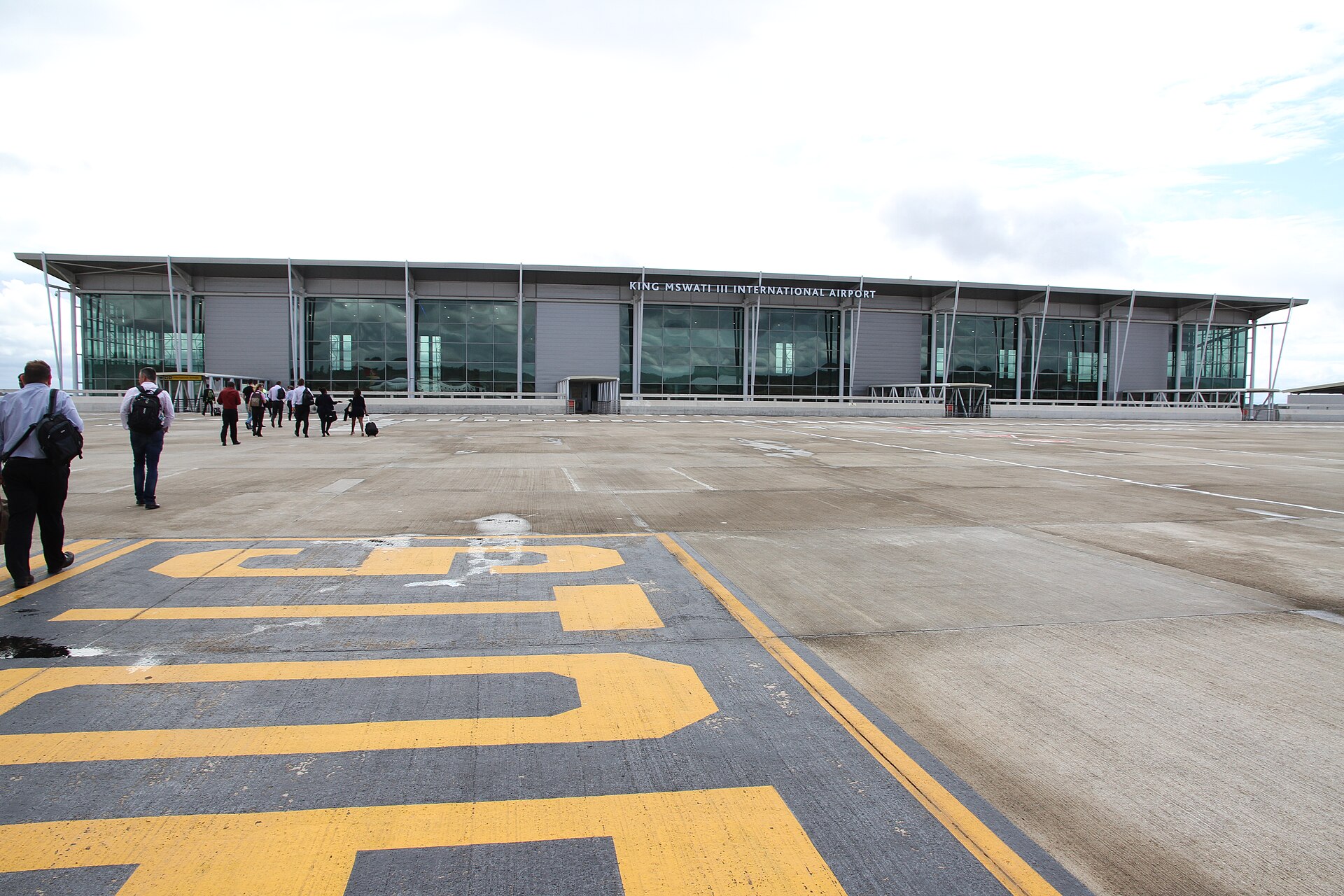Passengers walking across the apron towards the terminal of King Mswati III International Airport in Eswatini