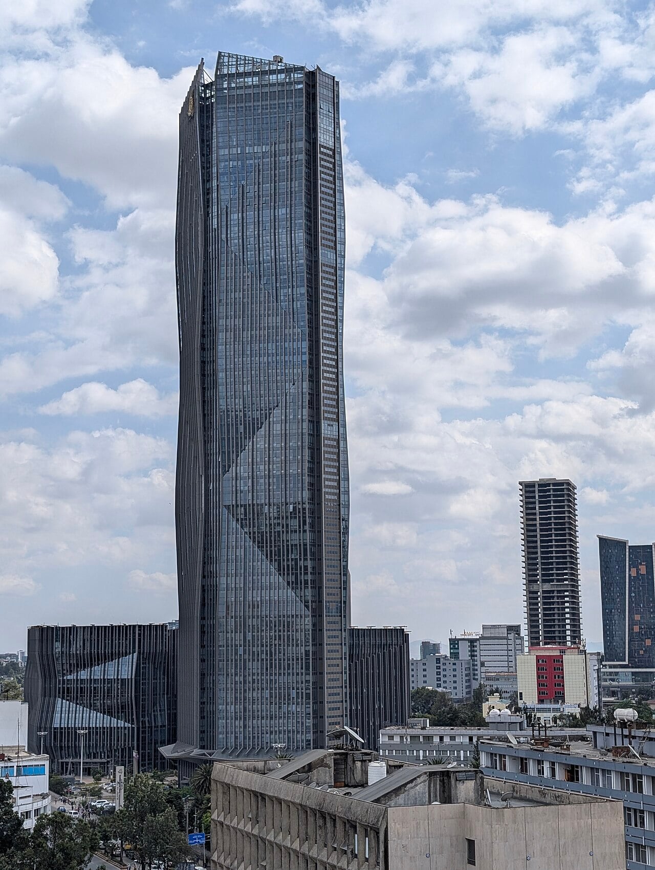 Tall glass head office tower of the Commercial Bank of Ethiopia under a cloudy sky in Addis Ababa
