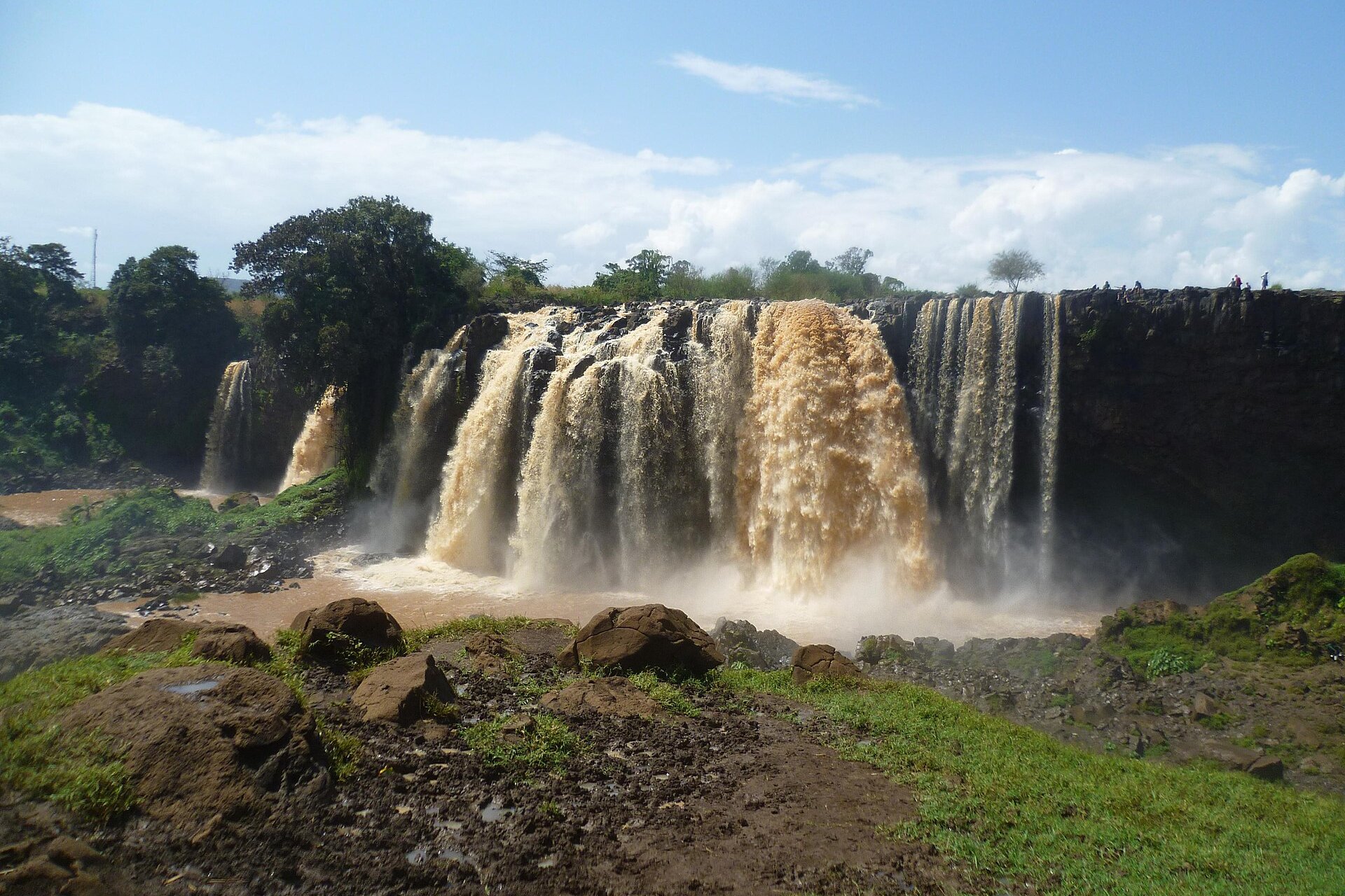 The Blue Nile Falls at Tis Issat near Bahir Dar, Ethiopia, with brown water pouring over a basalt cliff into a misty pool