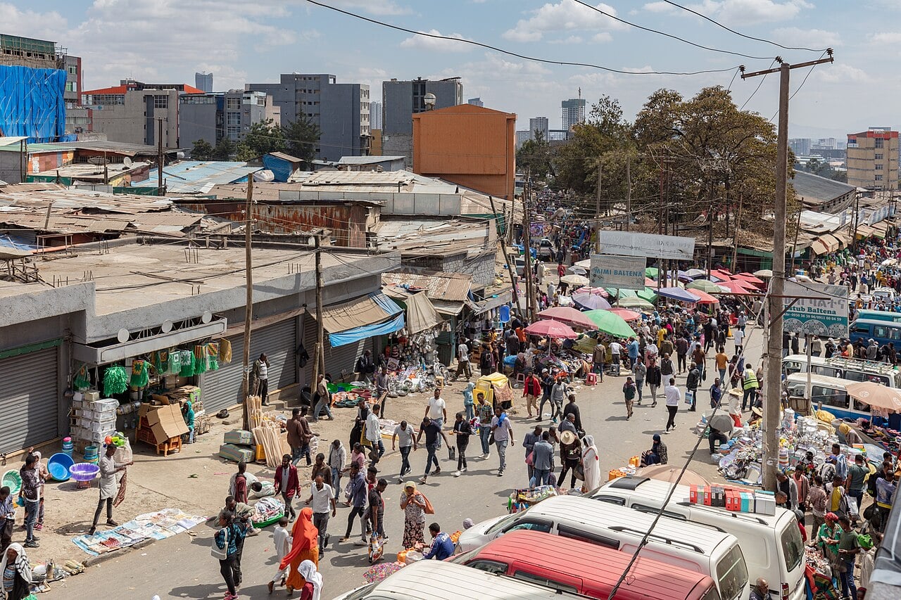 Crowded street at the Merkato market in Addis Ababa with stalls, minibuses and shoppers