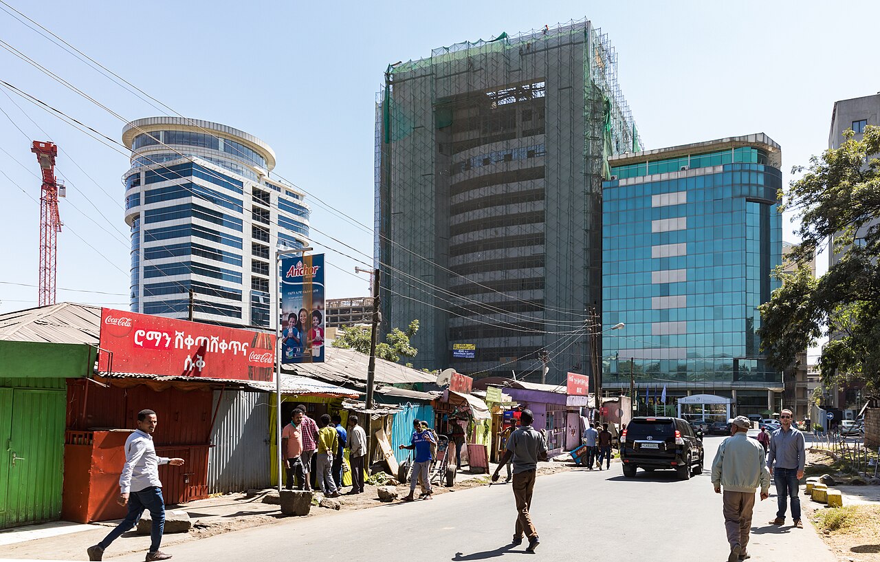 Office towers and street shops in central Addis Ababa under a blue sky