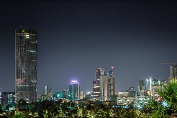 Addis Ababa skyline at night with a tall glass tower on the left and lit office buildings below a dark sky