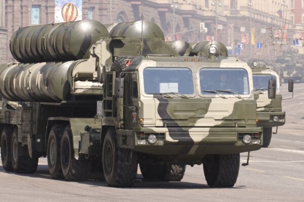 A camouflaged Russian S-400 air defence launcher truck with missile tubes raised drives down a city street during a parade