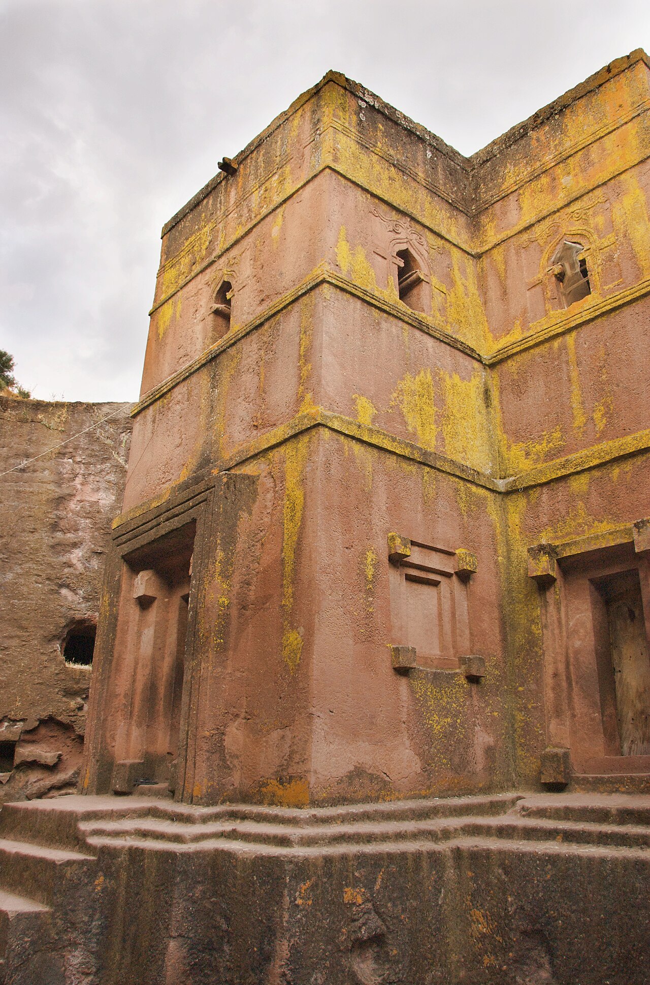 Bet Giorgis, a rock-hewn church in Lalibela, Ethiopia, with a stepped base and weathered pink-brown walls.