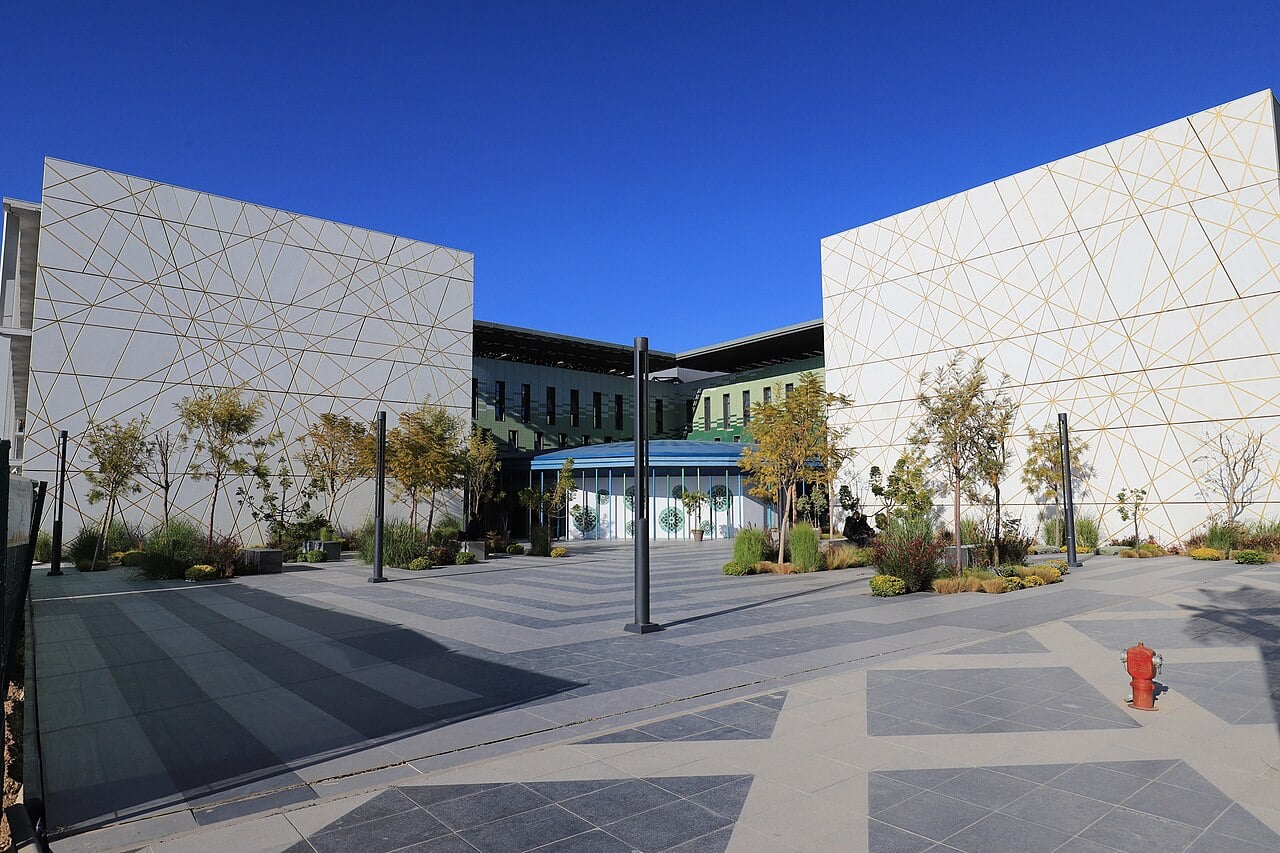 White facades with a gold geometric pattern frame a courtyard at Euromed University of Fès