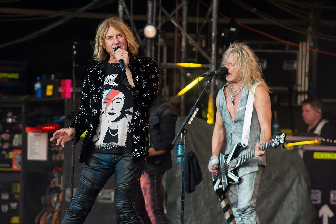 Def Leppard singer Joe Elliott and bassist Rick Savage performing on an open-air festival stage
