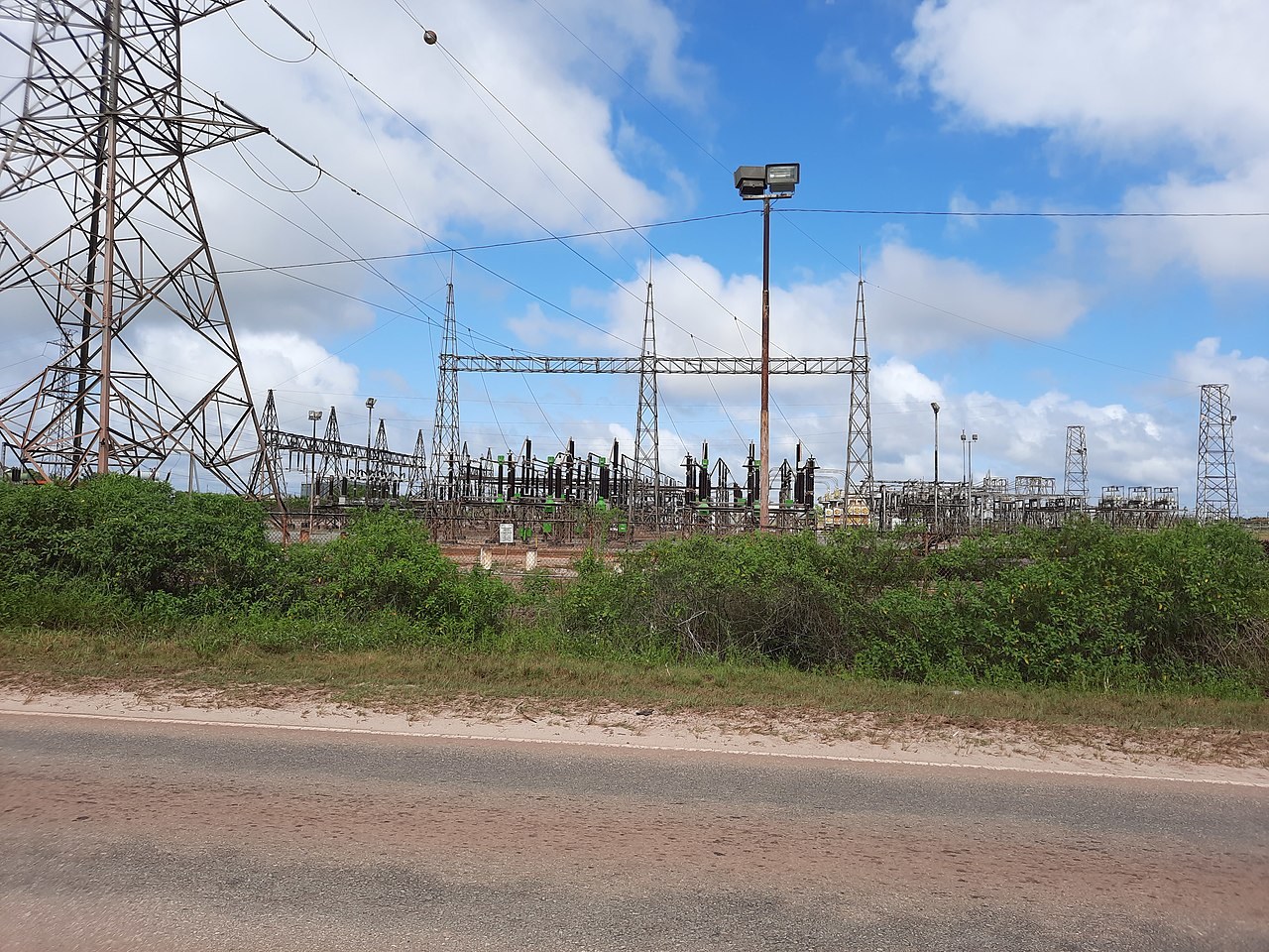 Suriname power cuts - Electricity substation and high-voltage pylons beside a road in Suriname