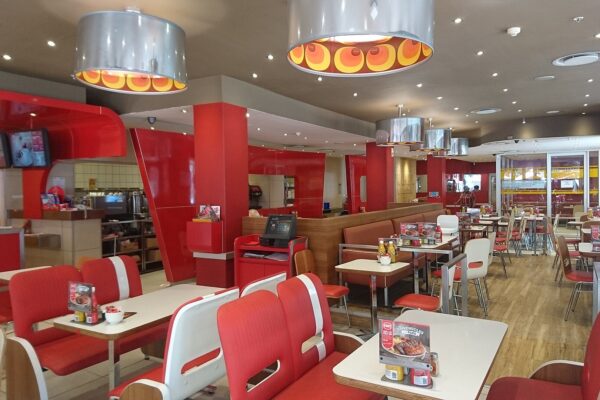 Interior of a Wimpy restaurant in South Africa with red booths and tables