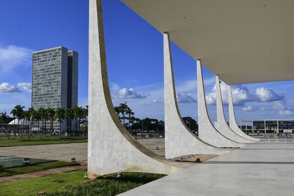 Marble colonnade of the Supreme Federal Court in Brasília with the Congress towers in the distance under a blue sky
