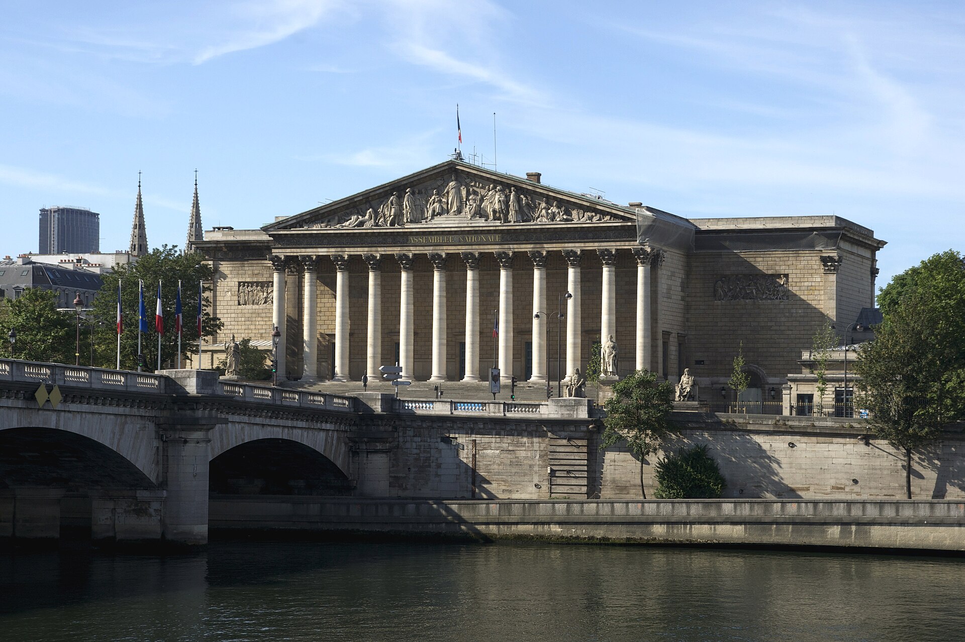 The colonnaded Palais Bourbon, seat of the French National Assembly, seen across the Seine under a blue sky