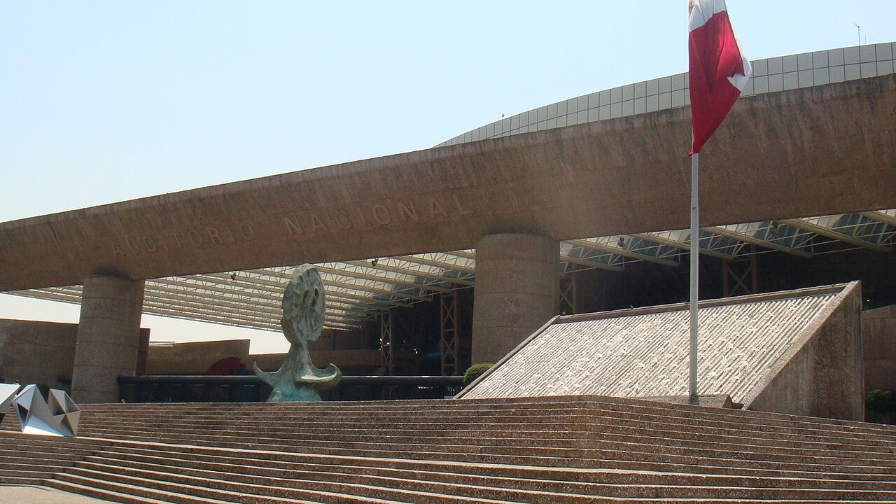 The front steps and entrance canopy of the Auditorio Nacional in Mexico City, with a Mexican flag.
