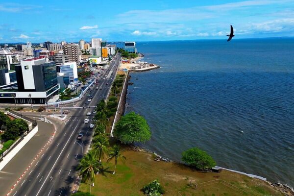 Aerial view of Libreville's seafront boulevard with office towers on one side and the Atlantic Ocean on the other
