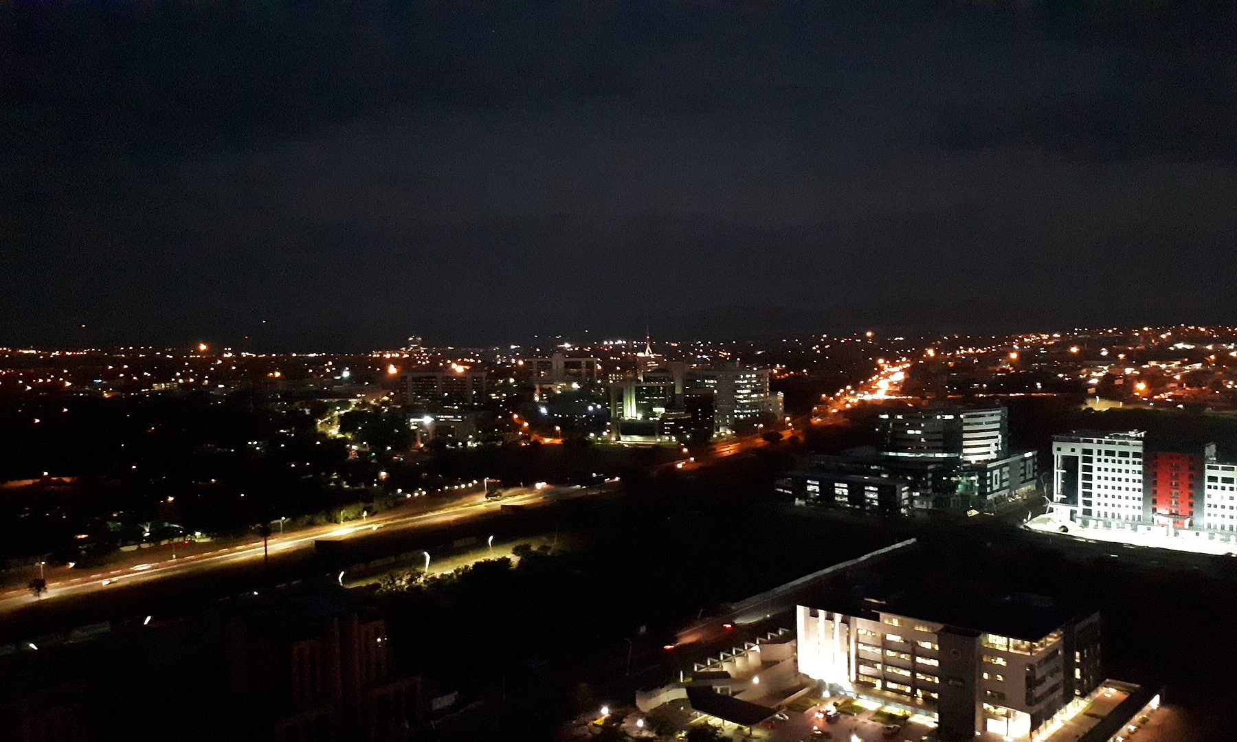 Gaborone, the capital of Botswana, at night, with lit office blocks and a main road seen from above
