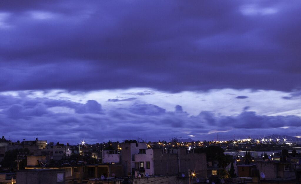 Night cityscape with buildings and cloudy sky