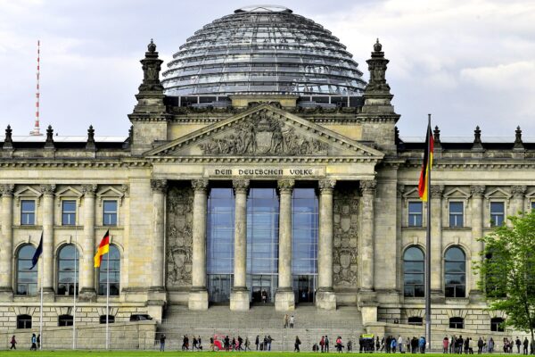 The Reichstag building in Berlin, seat of the German Bundestag, with a glass dome and German flag
