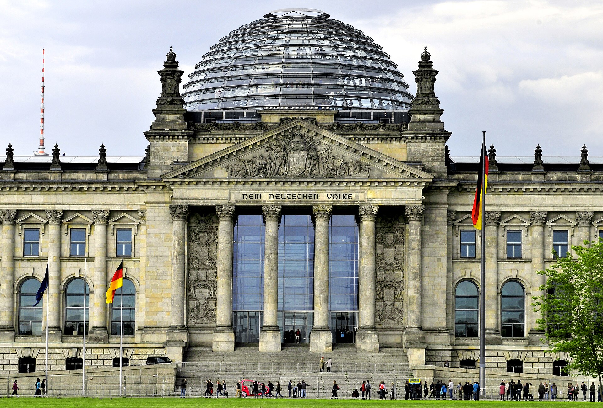 The Reichstag building in Berlin, seat of the German Bundestag, with a glass dome and German flag