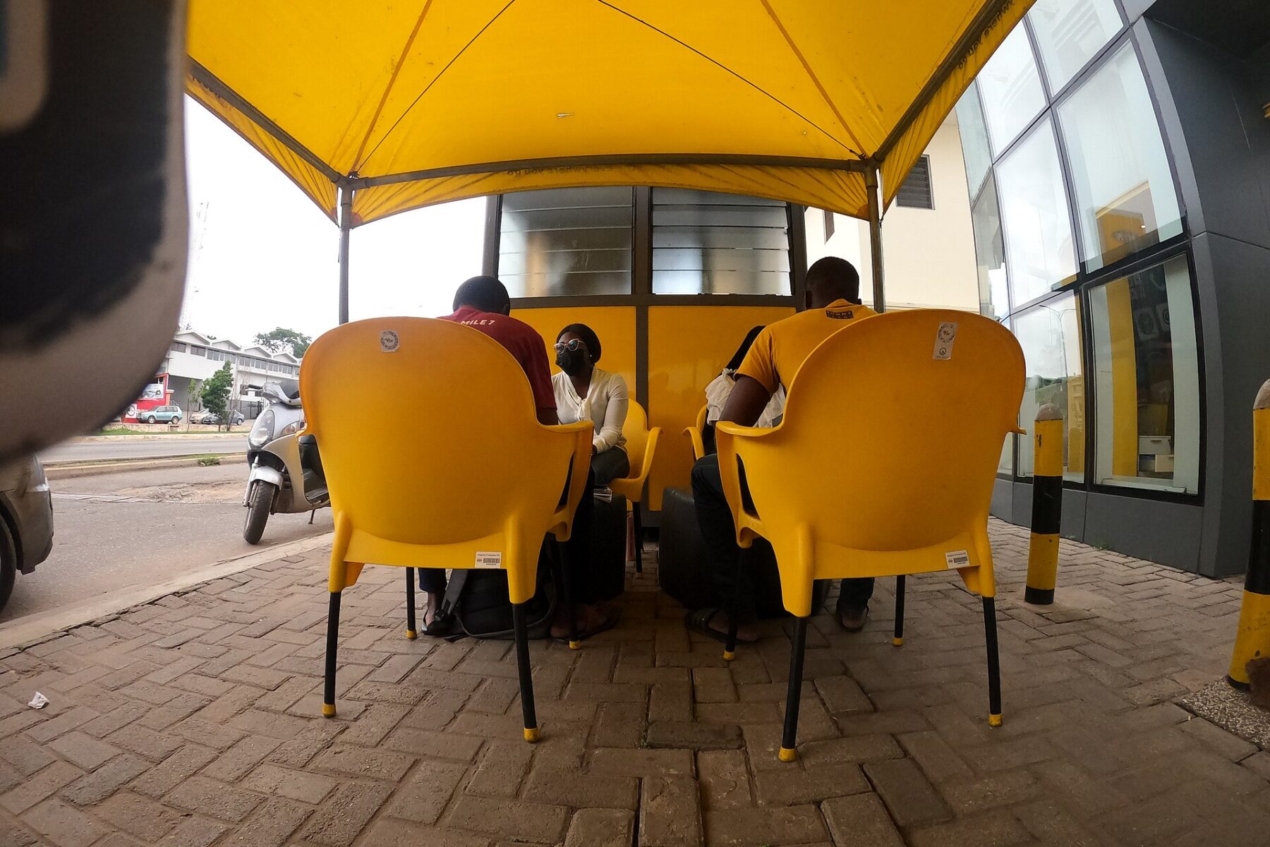 Customers seated under a yellow MTN canopy registering SIM cards in Ghana
