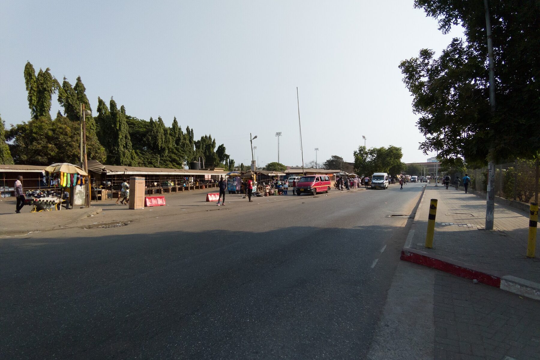 Market stalls and minibuses along Independence Avenue in Accra, Ghana