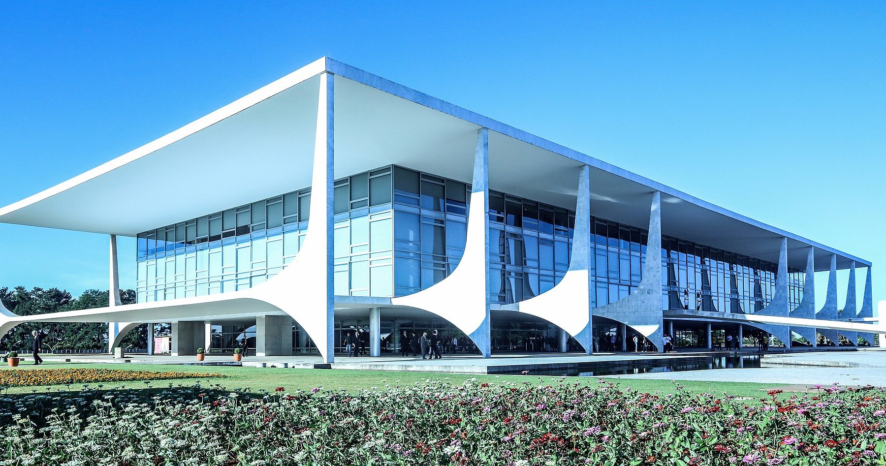 The Planalto Palace in Brasília, a low white building with curved columns and glass walls under a blue sky