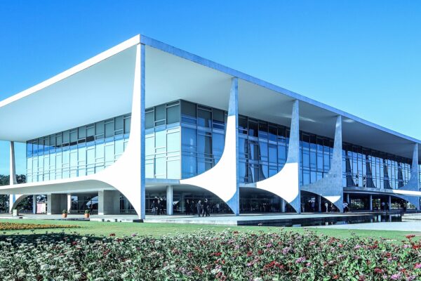 The Planalto Palace in Brasília, a low white building with curved columns and glass walls under a blue sky