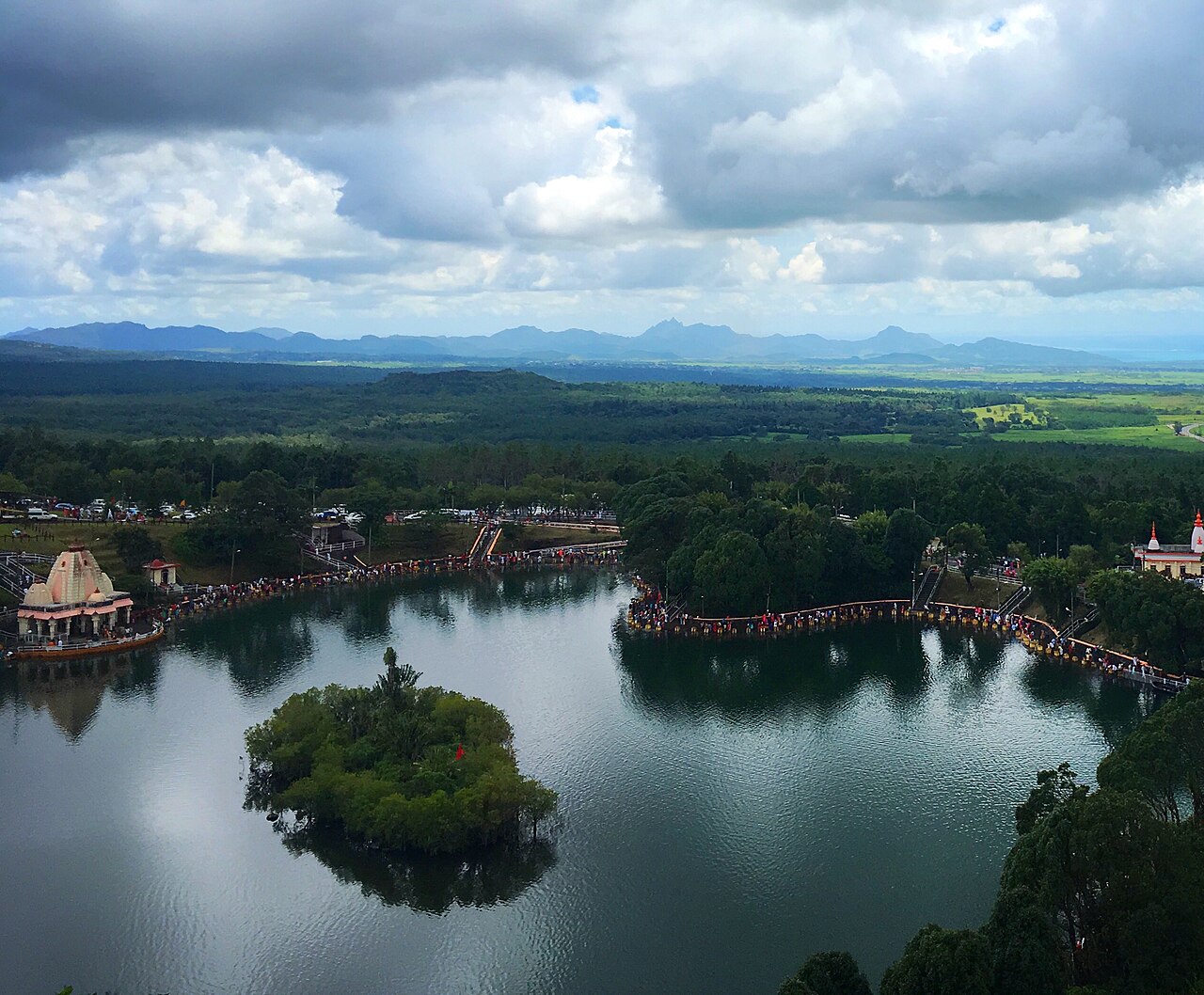 The Grand Bassin crater lake and Hindu temples in Mauritius, seen from a hillside above the water.
