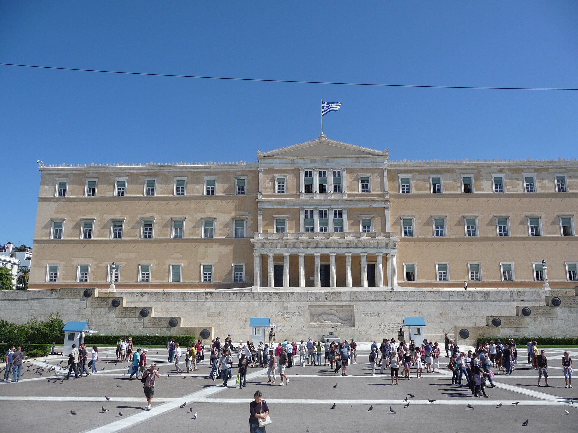 The Hellenic Parliament building on Syntagma Square in Athens with a Greek flag on the roof