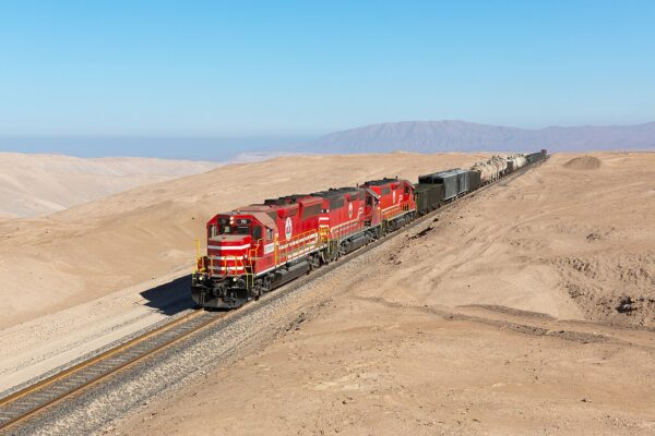 Red Southern Copper locomotives hauling a freight train across a desert near the Ilo to Toquepala line in southern Peru