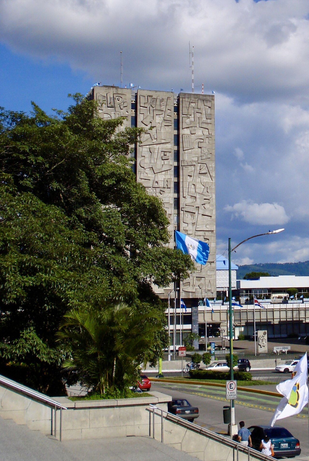 The Banco de Guatemala tower with its carved concrete facade and a Guatemalan flag in Guatemala City