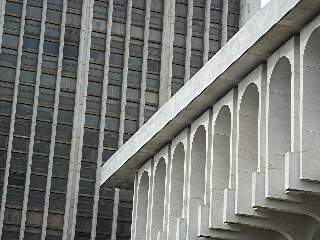 Grey modernist government buildings with tall vertical fins and a row of concrete arches in the Civic Centre of Guatemala City