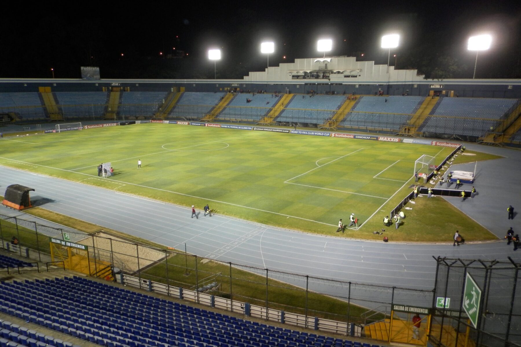 Floodlit Estadio Doroteo Guamuch Flores, Guatemala's national football stadium in Guatemala City, with blue seats and a green pitch at night
