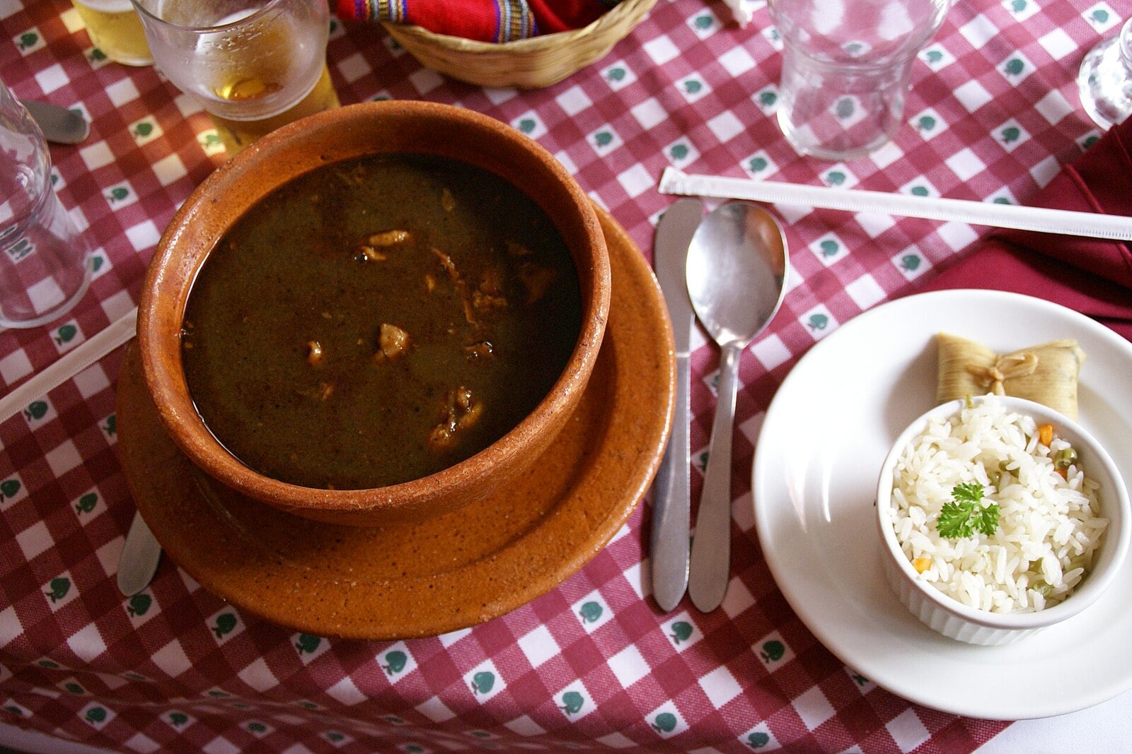 Guatemala food: kak’ik turkey soup in a clay bowl with rice and a tamalito