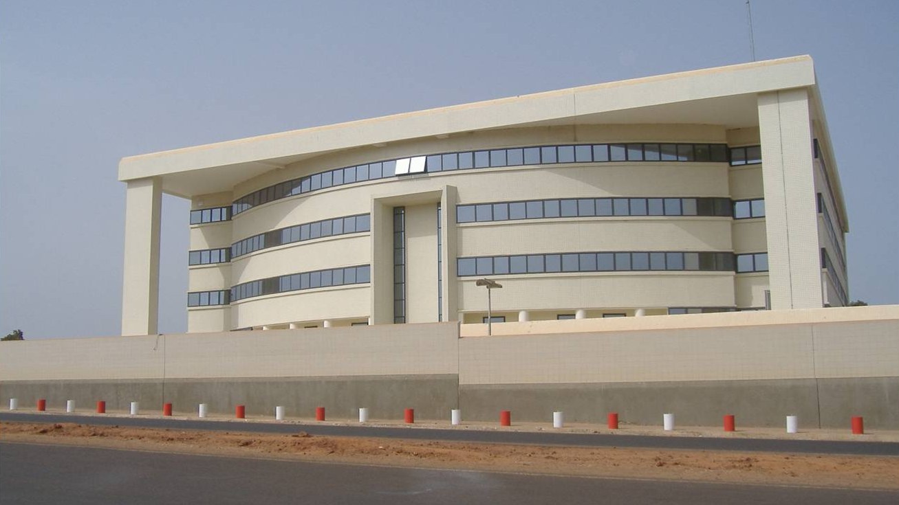 A cream-coloured office building seen from the road in Bissau, Guinea-Bissau, described as the national bank