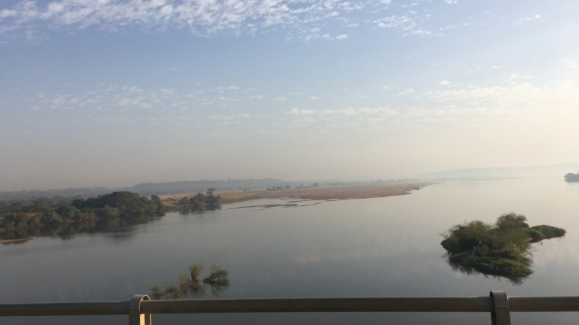 The Niger River seen from a bridge at Kouroussa in eastern Guinea, with green banks and a wide brown channel.