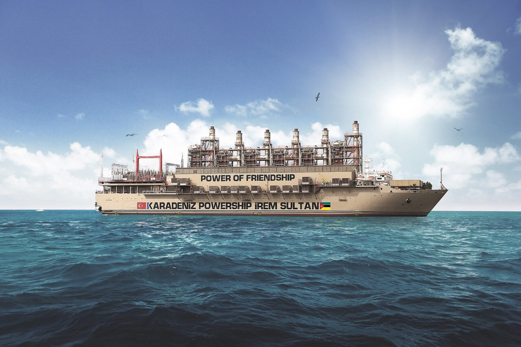 A Karadeniz powership, a floating power plant, afloat on a blue sea under a cloudy sky