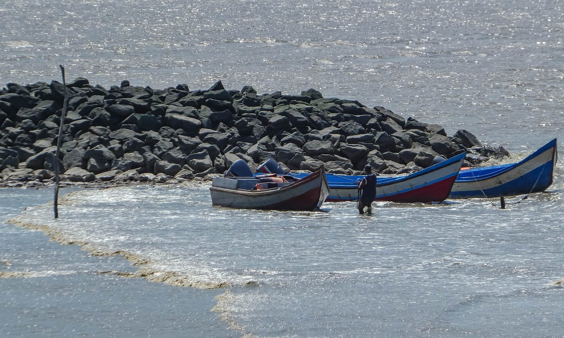 Missing Surinamese men case: open wooden boats moored by a rock jetty, waiting to carry passengers from Suriname to Guyana