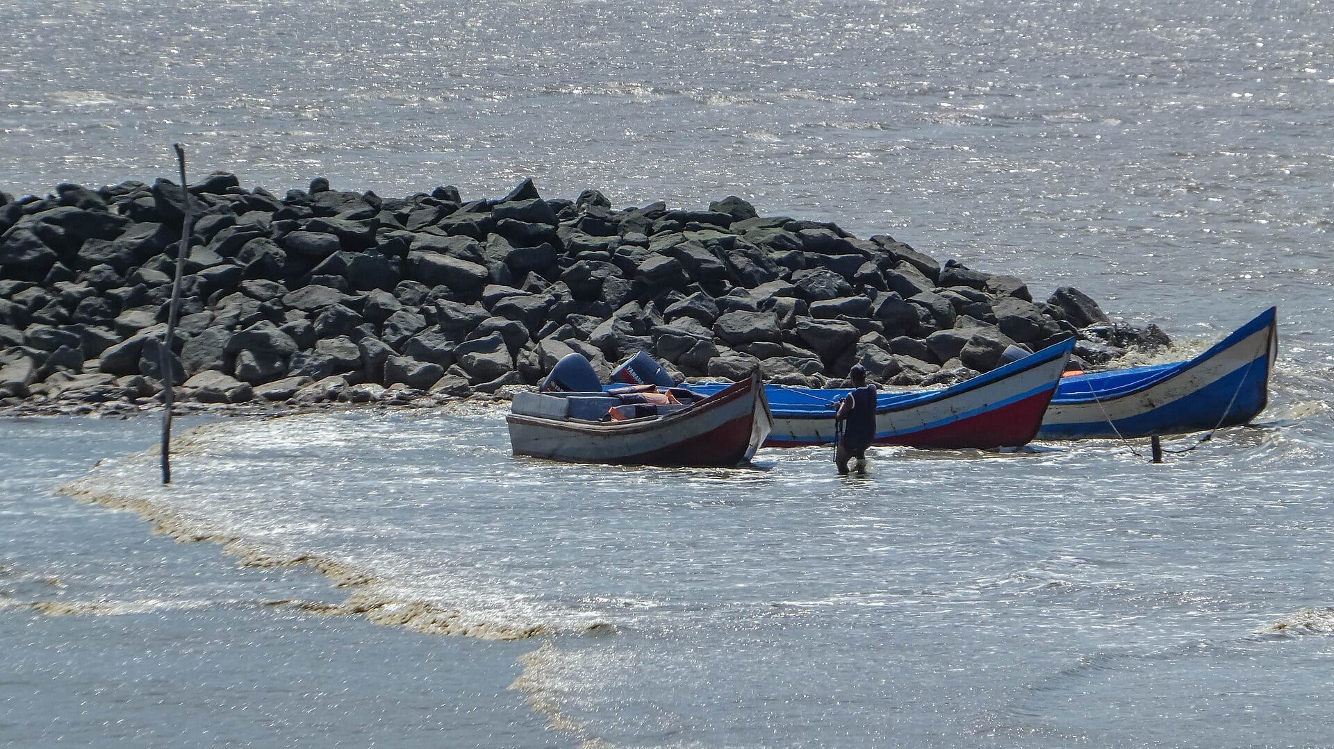 Missing Surinamese men case: open wooden boats moored by a rock jetty, waiting to carry passengers from Suriname to Guyana