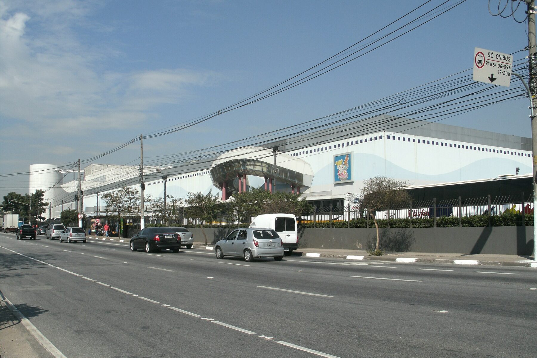 The long white facade of Shopping SP Market beside Avenida das Nações Unidas in the Jurubatuba area of São Paulo, with cars on the road