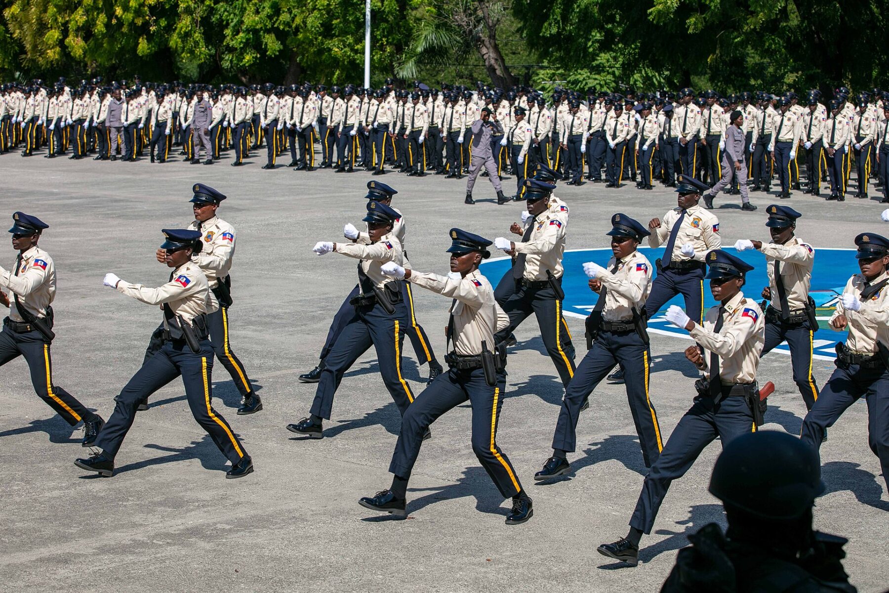 Haitian National Police graduates marching in formation on a parade ground in Port-au-Prince