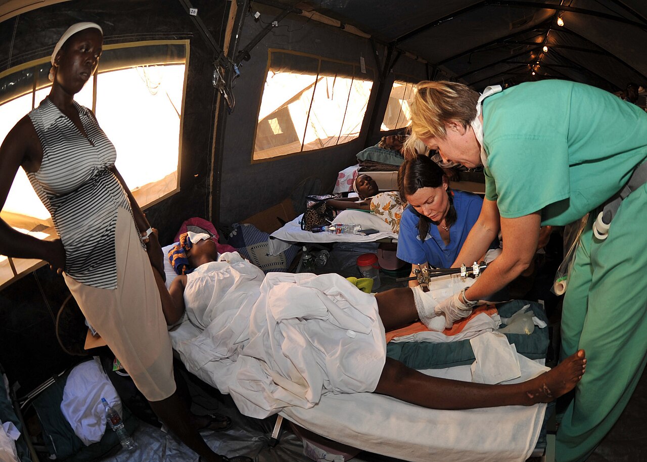 Medical staff treat a Haitian woman on a bed in a tent at the Milot hospital near Cap-Haïtien in 2010