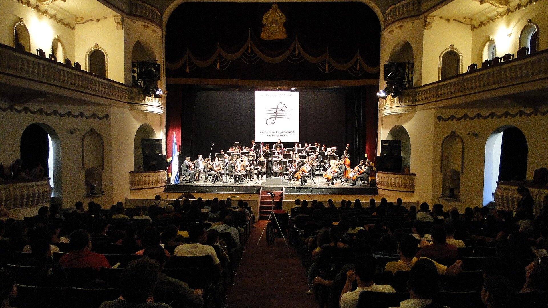 The Honduras Philharmonic Orchestra performing on stage at the Manuel Bonilla National Theater before an audience