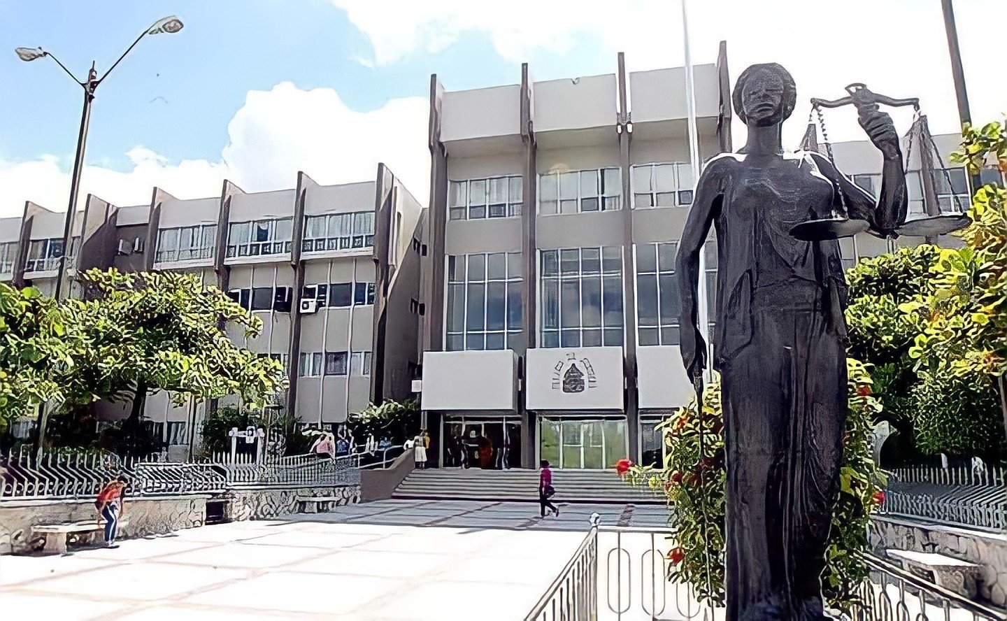Front of the Supreme Court of Justice building in Tegucigalpa, with a statue of Lady Justice holding scales in the foreground