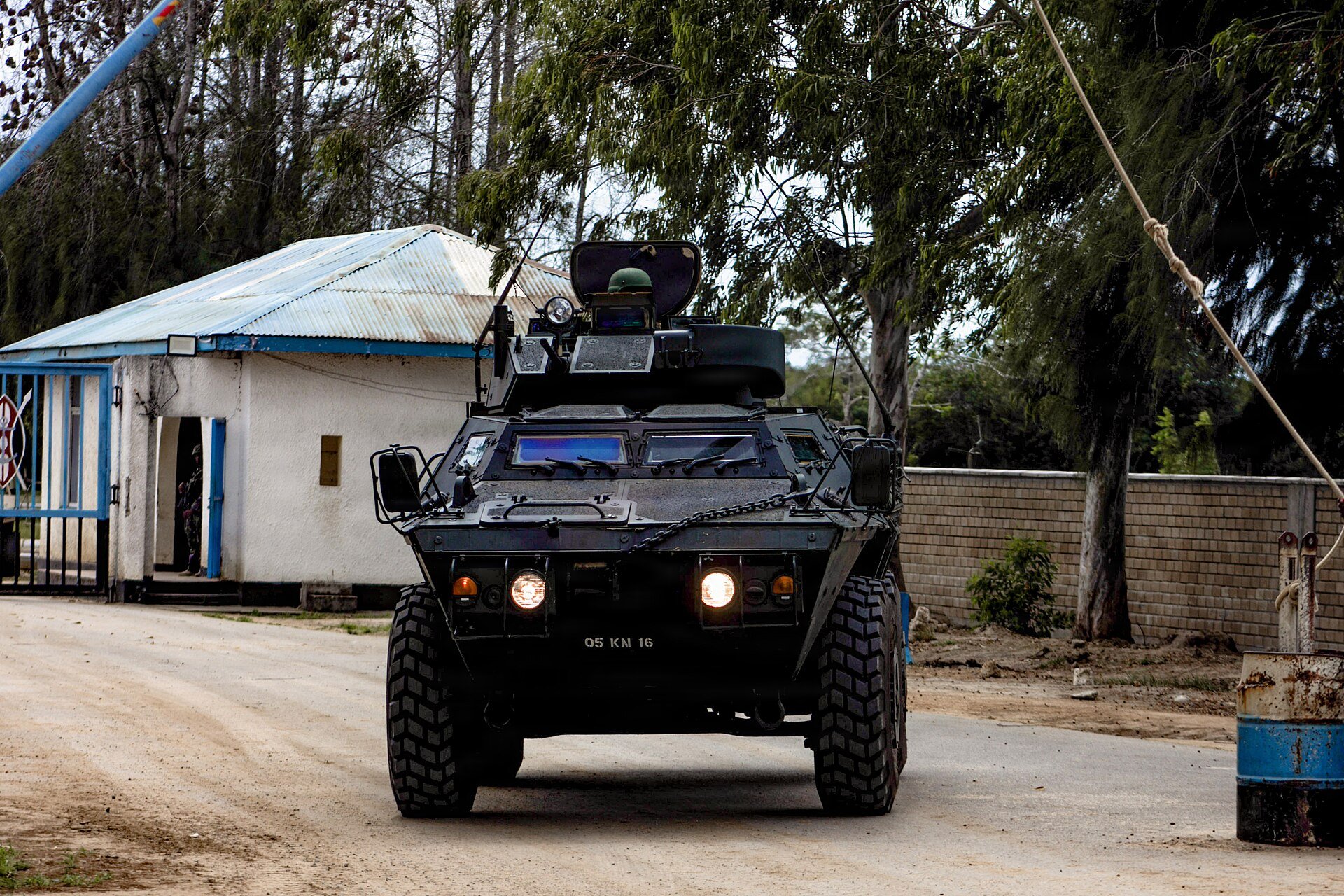 A Kenyan armoured vehicle with a turret hatch open drives through a gate at the Manda Bay base in Kenya
