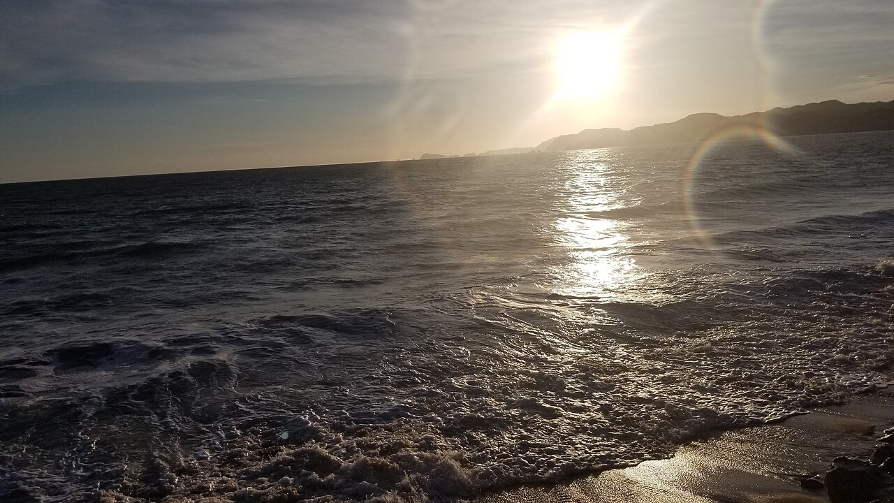 Waves roll onto a beach at Manzanillo on Mexico's Pacific coast in the light of a low sun
