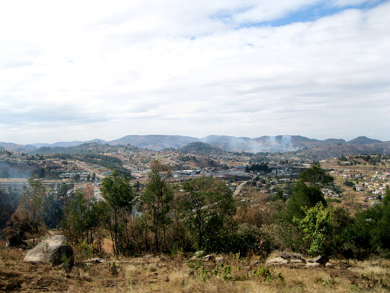 View over Mbabane, the capital of Eswatini, with houses spread across hills and mountains in the distance