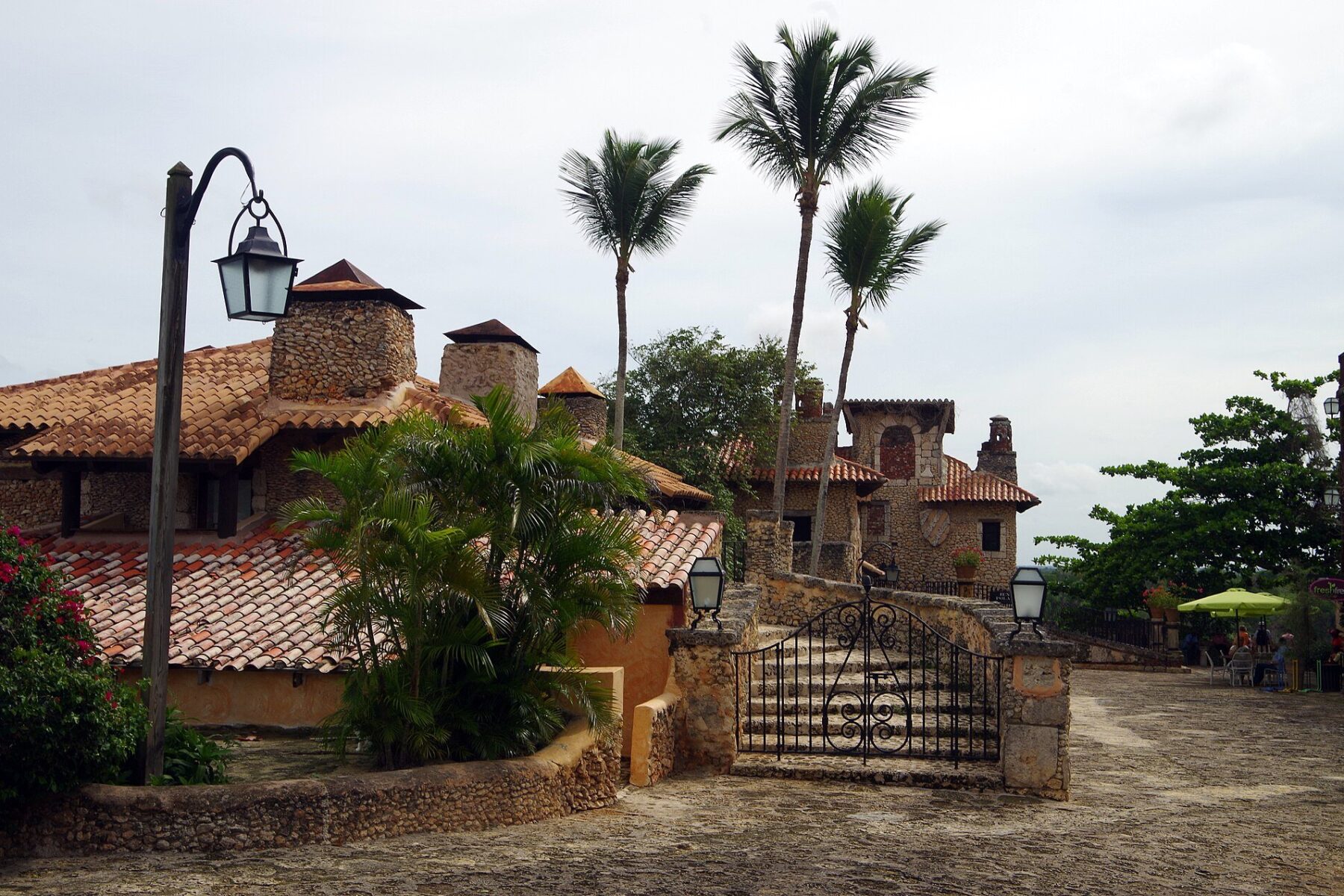 Cobblestone square, stone buildings with clay tile roofs and palm trees in Altos de Chavón, a Mediterranean-style village at Casa de Campo near La Romana, Dominican Republic