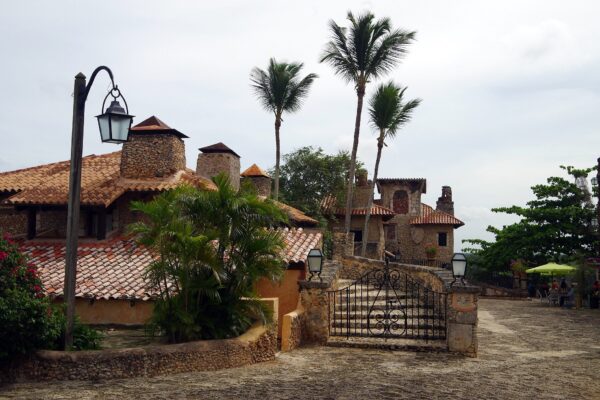 Cobblestone square, stone buildings with clay tile roofs and palm trees in Altos de Chavón, a Mediterranean-style village at Casa de Campo near La Romana, Dominican Republic
